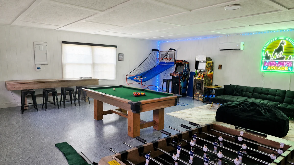 Digitally edited image: the real arcade with its pool table uncovered and garage-door ceiling hardware digitally removed