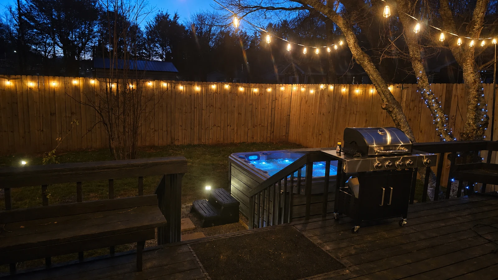Mojo Manor hot tub at night with the cover open, blue underwater lighting and jets running