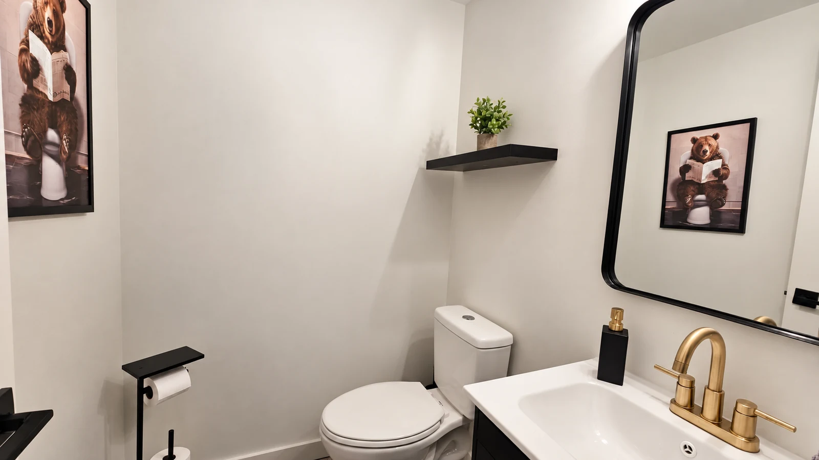 Downstairs half bath powder room with gold fixtures and bear artwork reflected in mirror